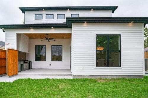 Small backyard patio with covered seating area and modern house exterior