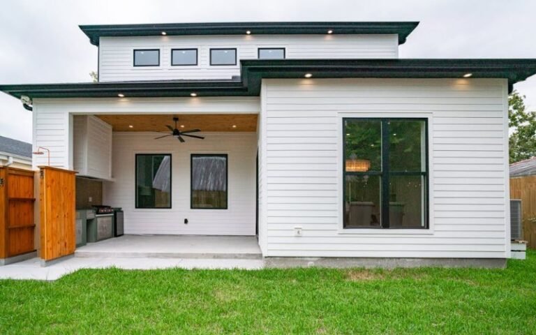 Small backyard patio with covered seating area and modern house exterior