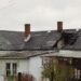 House damaged by natural disaster with broken roof and structural damage