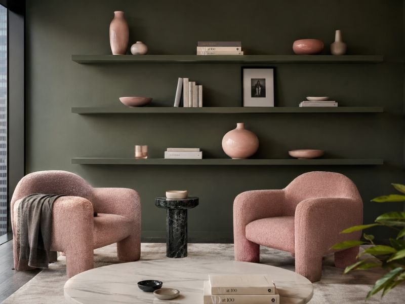 Pink boucle chairs with dark green walls