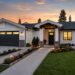 Modern home exterior with upgraded landscaping, lighting, driveway, and fresh siding