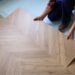 Contractor installing modern wood-look flooring in a rental property renovation