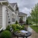 Homeowner preparing house for rainy season maintenance with clean gutters and drainage