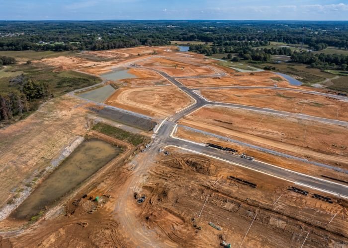 Raw land being transformed into a residential development with roads and utilities