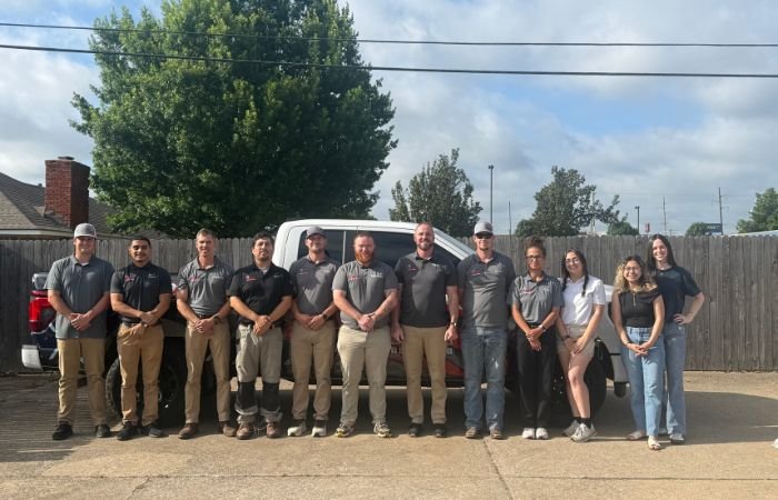 Professional roofing inspection team standing together outside with company vehicle