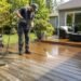 Professional cleaning a weathered wooden deck during restoration
