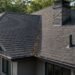 Residential roof showing valley, chimney flashing, roof vent, and roof edges
