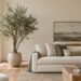 Realistic faux olive tree beside a cream sofa in a modern living room