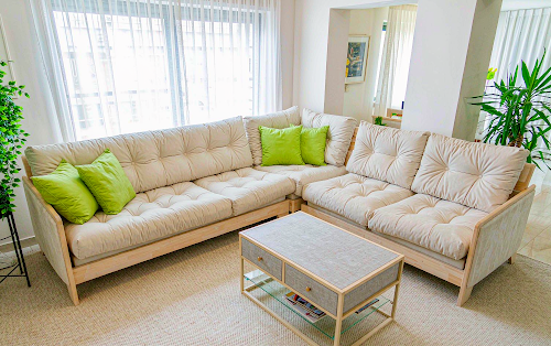 Cream sofa and matching loveseat arranged in an L shape in a bright living room.