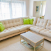 Cream sofa and matching loveseat arranged in an L shape in a bright living room.