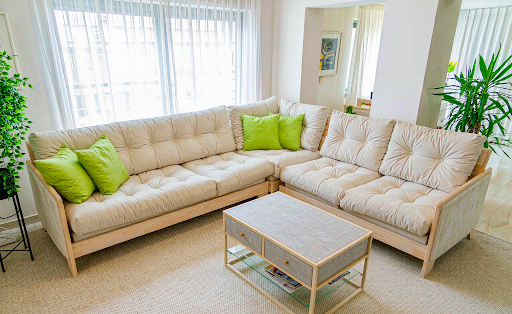 Cream sofa and matching loveseat arranged in an L shape in a bright living room.